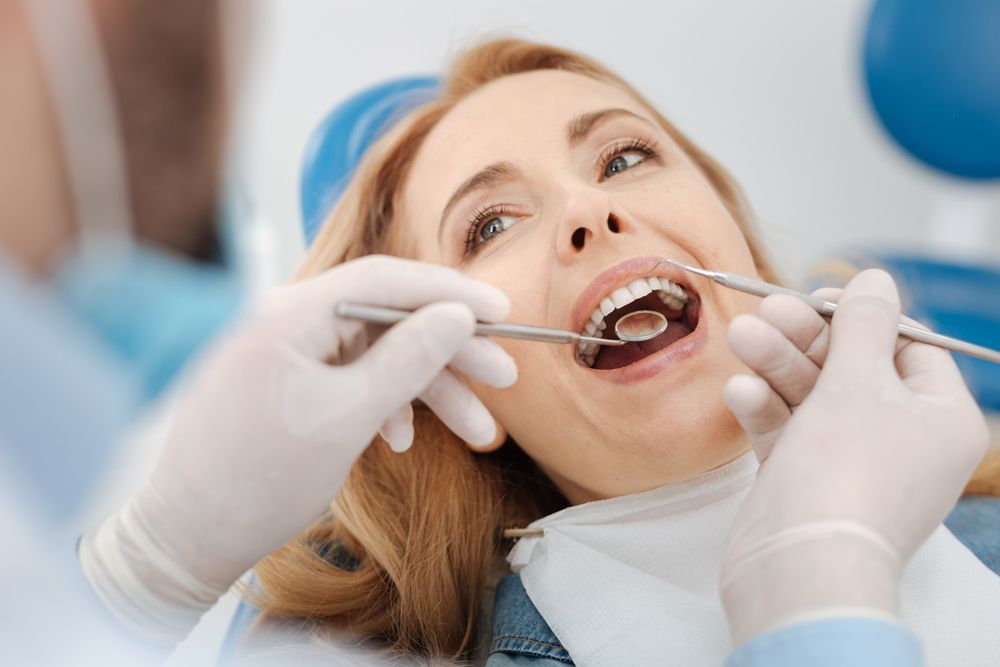 Dentist examining a patient's gums for signs of periodontal disease