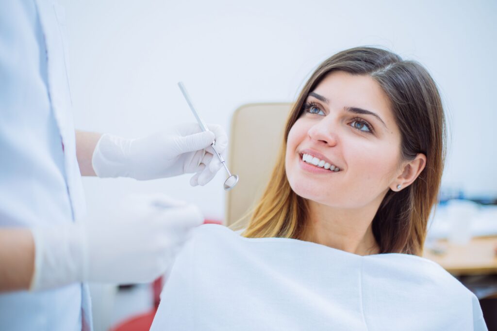 Woman looking at her tooth-colored filling results in a dental mirror