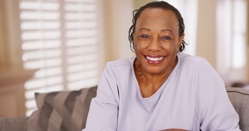 Smiling woman comparing same-day and traditional dental crown options