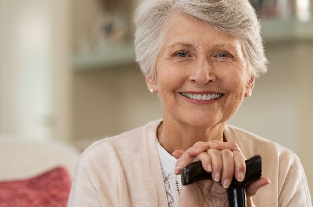 Smiling senior woman who received a dental implant at All Smile Care