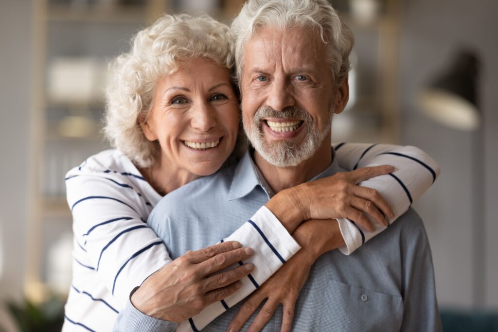 Smiling senior couple enjoying secure snap-in dentures