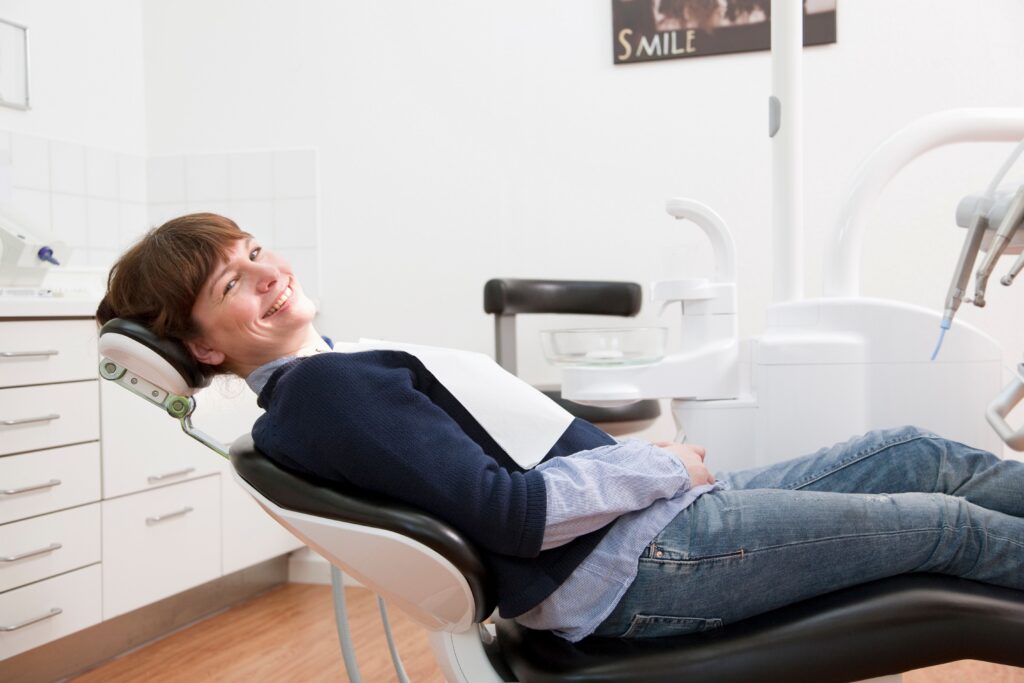 Smiling woman relaxing in the dental chair during a routine cleaning