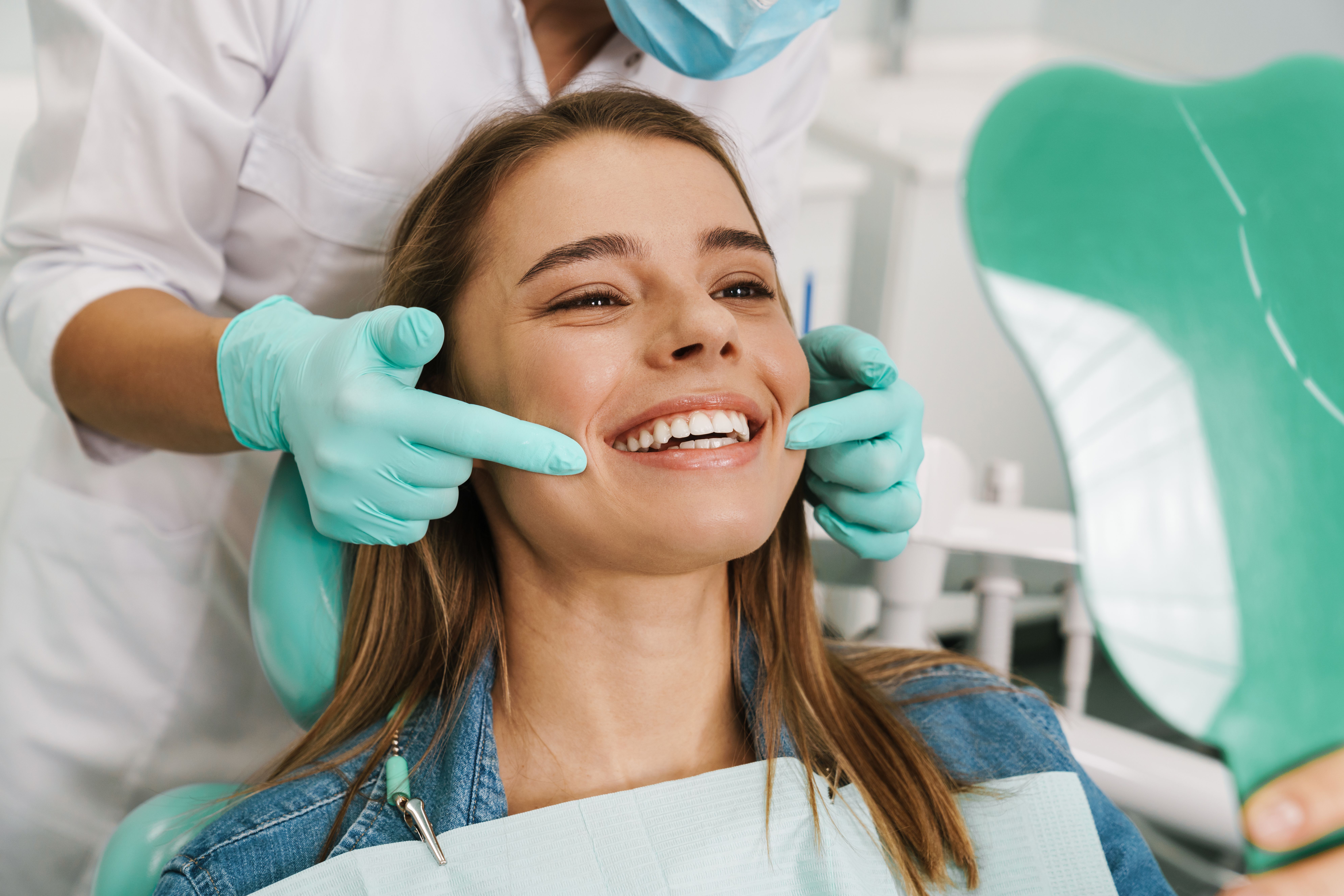 Woman admiring her whiter smile in a mirror after professional teeth whitening