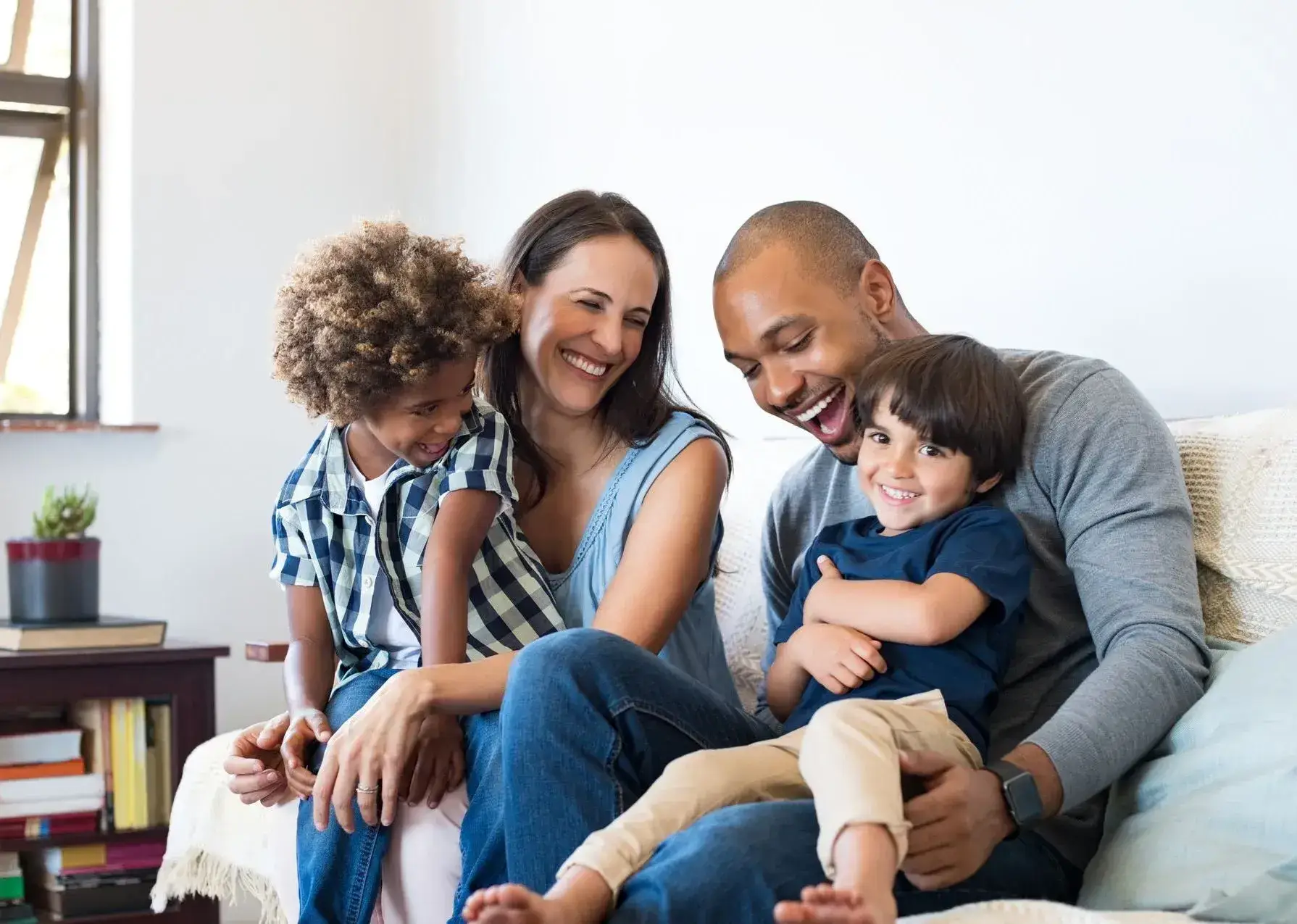 Smiling family with two children sitting together at home